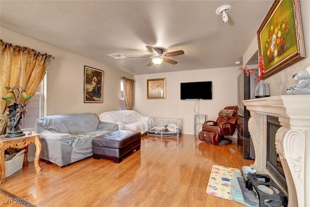 9065 W Torino Ave, Las Vegas, NV 89148 - living area featuring light wood-style floors, a ceiling fan, and a glass covered fireplace