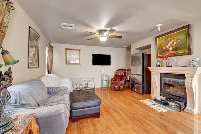 9065 W Torino Ave, Las Vegas, NV 89148 - living area featuring light wood-style flooring, a ceiling fan, and a glass covered fireplace