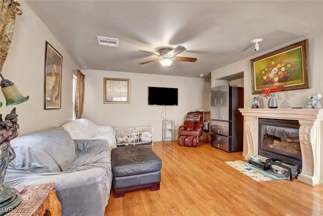 9065 W Torino Ave, Las Vegas, NV 89148 - living room featuring light wood-style flooring, a ceiling fan, and a fireplace with flush hearth