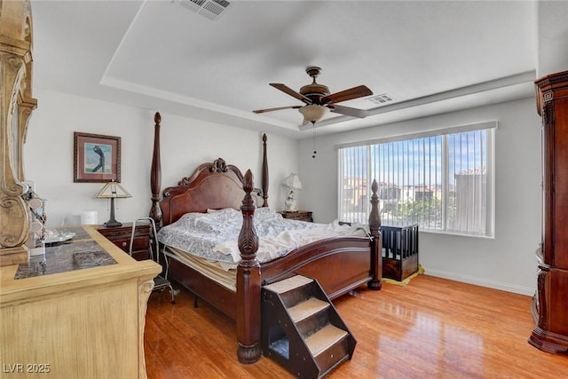9065 W Torino Ave, Las Vegas, NV 89148 - bedroom with light wood-style flooring, baseboards, ceiling fan, and a tray ceiling