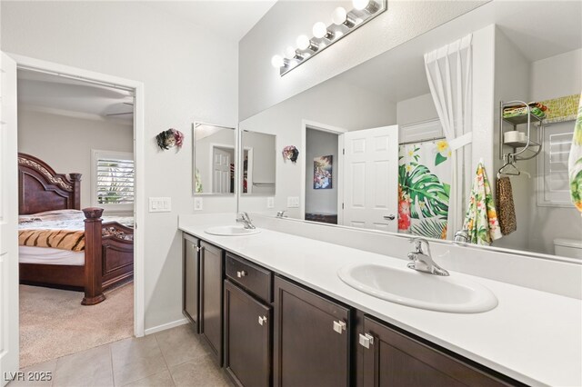 2720 Mickey Mantle Ct, Las Vegas, NV 89108 - bathroom featuring double vanity, tile patterned floors, ensuite bath, baseboards, and toilet