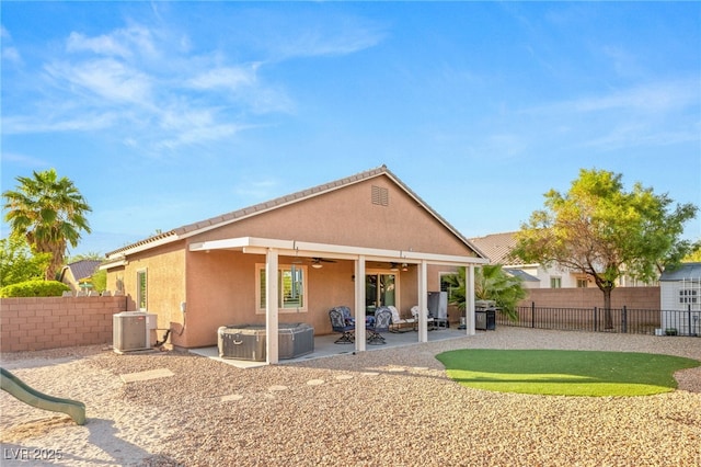 2720 Mickey Mantle Ct, Las Vegas, NV 89108 - rear view of property with a ceiling fan, a hot tub, stucco siding, cooling unit, and a fenced backyard