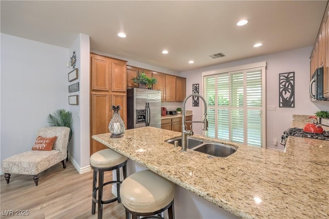 kitchen with stainless steel fridge, black microwave, a sink, a kitchen bar, and a peninsula