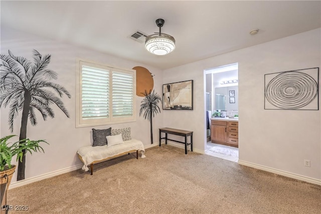 living area featuring light colored carpet and baseboards
