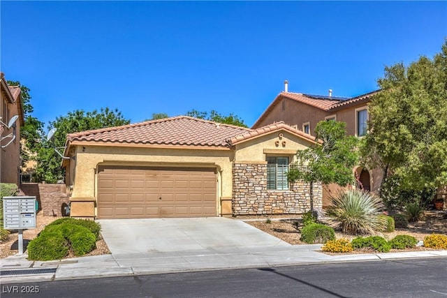 mediterranean / spanish home featuring stucco siding, an attached garage, a tile roof, concrete driveway, and stone siding