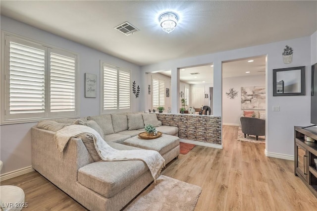 living area featuring light wood-style flooring and baseboards