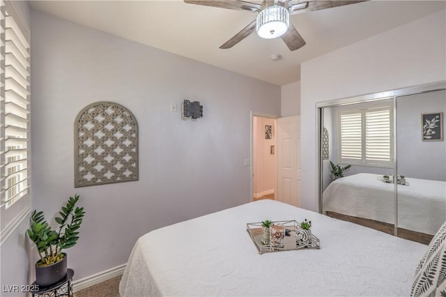 carpeted bedroom with baseboards, ceiling fan, and a closet