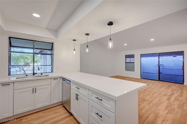 8412 Mulcahy Ave, Las Vegas, NV 89145 - kitchen with a sink, dishwasher, light wood finished floors, a peninsula, and light countertops