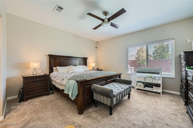 bedroom with light colored carpet, baseboards, and a ceiling fan