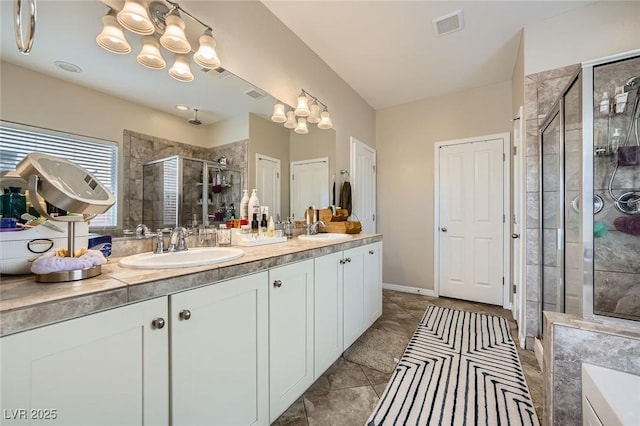 full bath with a shower stall, double vanity, and tile patterned floors