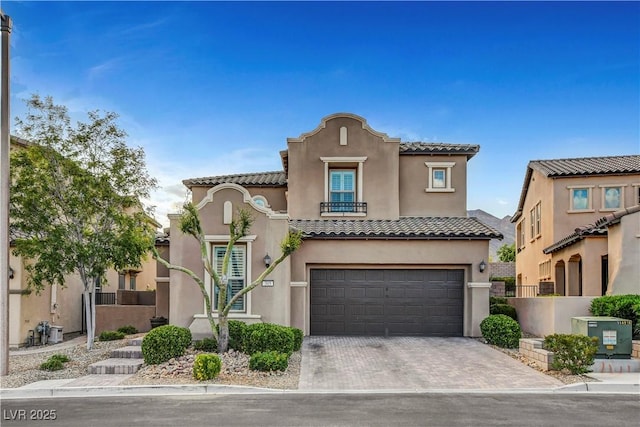 mediterranean / spanish house with stucco siding, a garage, a tile roof, driveway, and fence