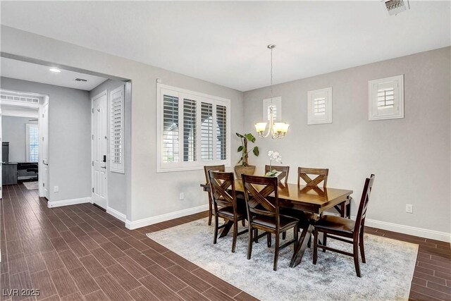 dining space featuring baseboards, a chandelier, dark wood-type flooring, and recessed lighting