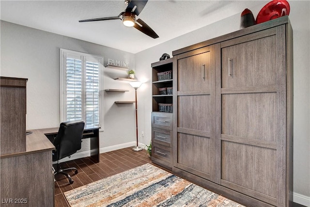office area featuring baseboards, ceiling fan, and dark wood finished floors