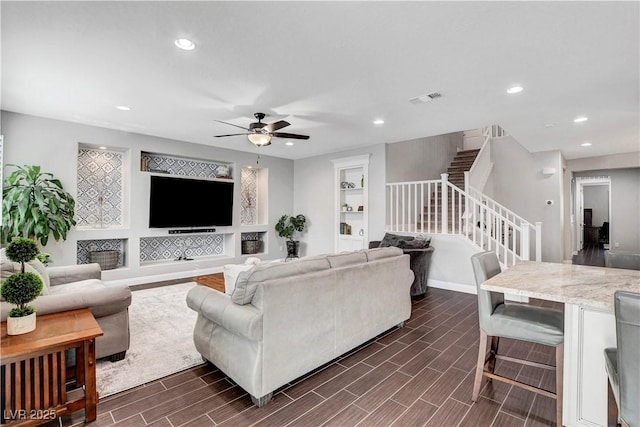 living area with stairs, ceiling fan, dark wood-type flooring, recessed lighting, and baseboards
