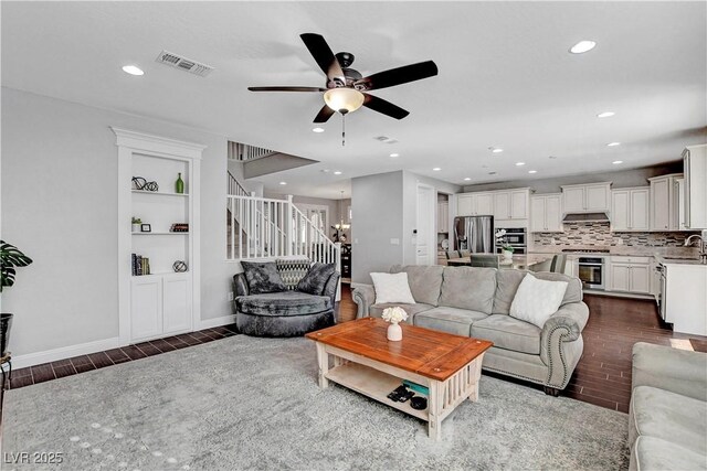living room featuring ceiling fan, recessed lighting, dark wood-style floors, baseboards, and built in features