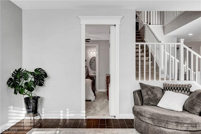 sitting room with wood tiled floors, stairway, and baseboards