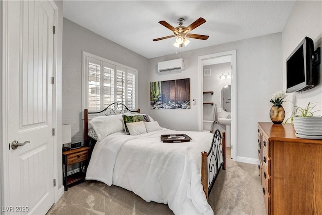 bedroom with a wall mounted AC, light carpet, baseboards, and connected bathroom