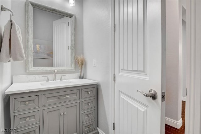 bathroom featuring vanity, baseboards, and wood finished floors