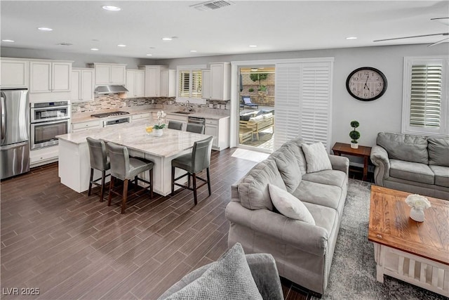 living room with dark wood finished floors, recessed lighting, and ceiling fan