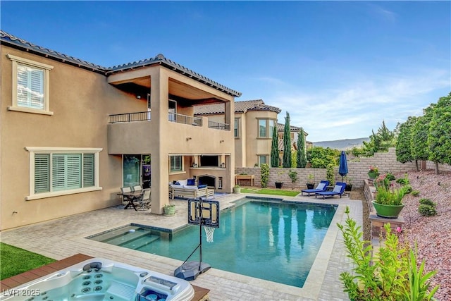 view of swimming pool with an outdoor hot tub, exterior fireplace, a patio area, and fence