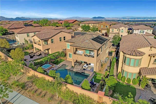 aerial view of residential area with a pool and a mountainous background