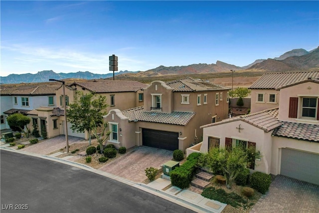 view of front facade featuring a mountain view, a tiled roof, stucco siding, and a residential view