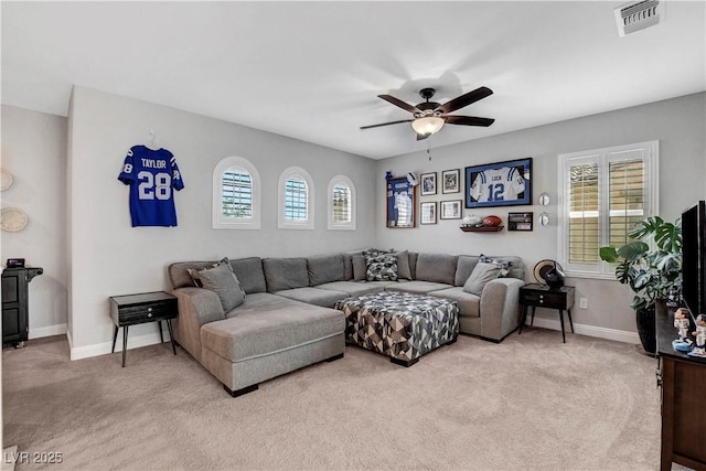 carpeted living room with a ceiling fan and baseboards