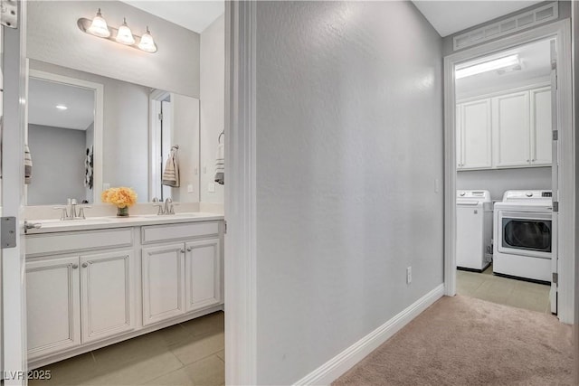laundry room featuring independent washer and dryer, baseboards, light tile patterned floors, and light carpet