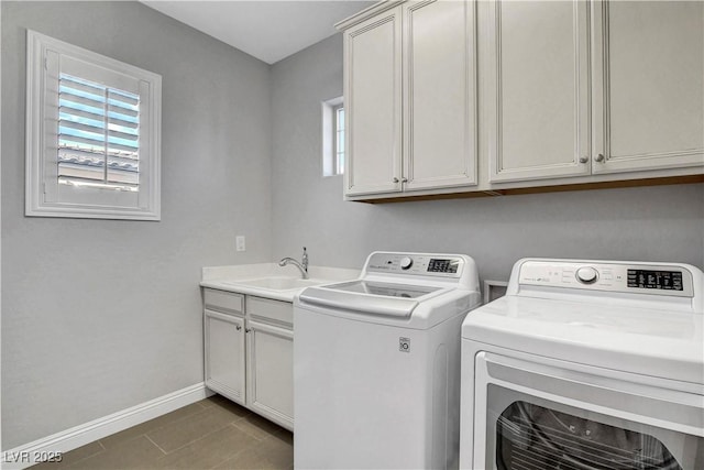 laundry room with plenty of natural light, cabinet space, washing machine and dryer, and baseboards