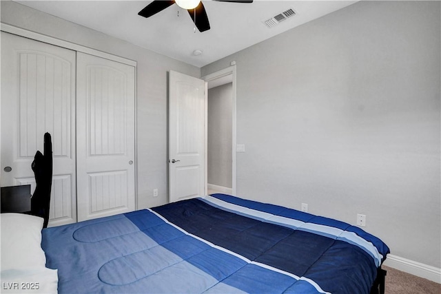 carpeted bedroom featuring a closet, baseboards, and a ceiling fan