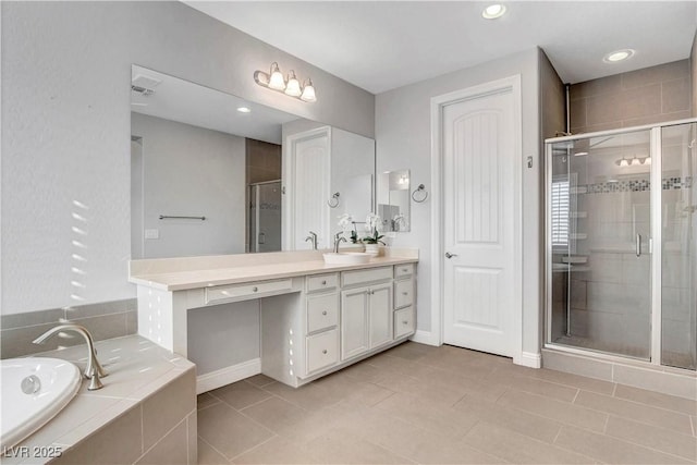 bathroom with a shower stall, a garden tub, vanity, and tile patterned floors