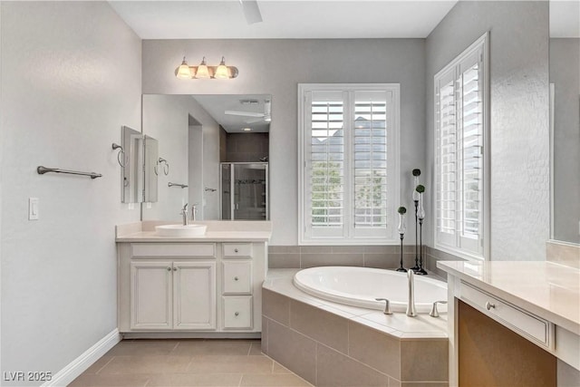 bathroom with a shower stall, a garden tub, tile patterned flooring, vanity, and baseboards