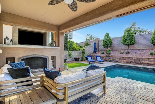 view of swimming pool with a patio area, a fenced backyard, ceiling fan, and an outdoor living space with a fireplace