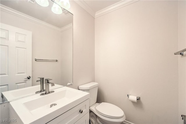 bathroom featuring toilet, vanity, crown molding, and baseboards