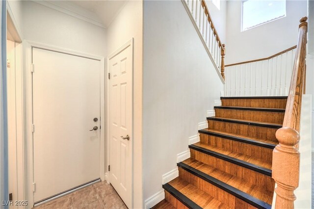 stairway with baseboards and ornamental molding
