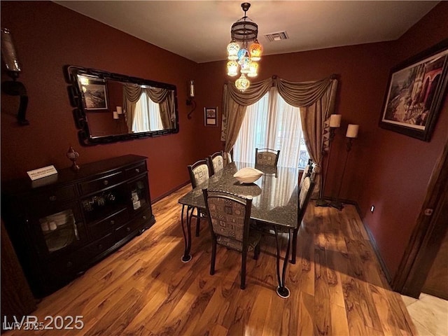 dining room with plenty of natural light, wood finished floors, and a chandelier