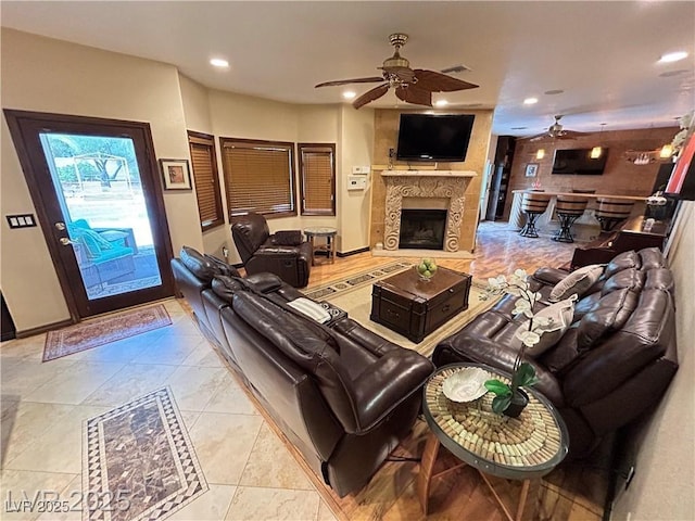 living area featuring ceiling fan, a fireplace, recessed lighting, and baseboards