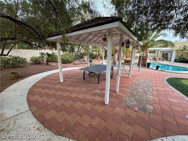 view of property's community featuring a gazebo, a swimming pool, fence, and a patio area
