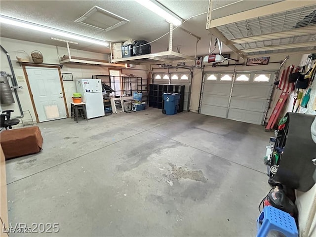 garage with a garage door opener and freestanding refrigerator