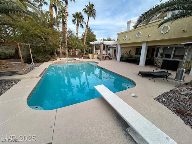 view of pool with a pergola, a patio area, a diving board, and a pool with connected hot tub