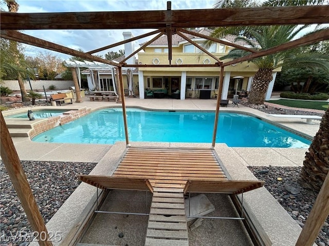view of swimming pool with a patio and a pool with connected hot tub