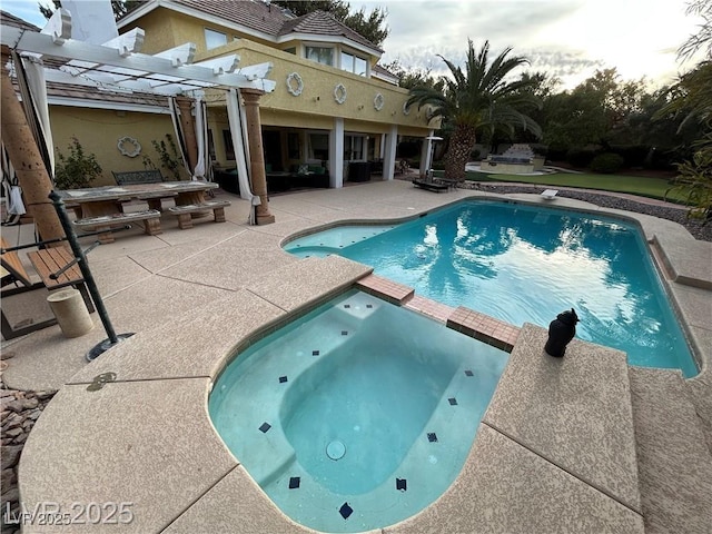 view of pool with a patio area, a pergola, and a pool with connected hot tub