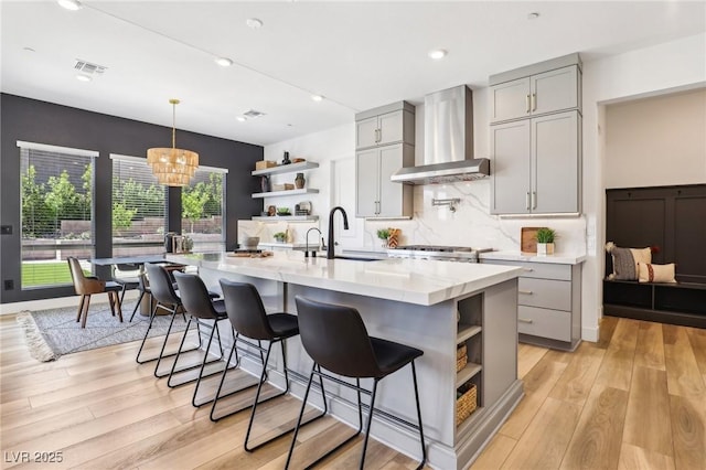 12155 Sage Thunder Ave, Las Vegas, NV 89138 - kitchen with open shelves, wall chimney exhaust hood, gray cabinets, a sink, and a chandelier