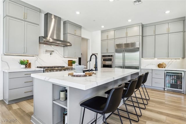 12155 Sage Thunder Ave, Las Vegas, NV 89138 - kitchen with gray cabinetry, wall chimney exhaust hood, wine cooler, open shelves, and appliances with stainless steel finishes