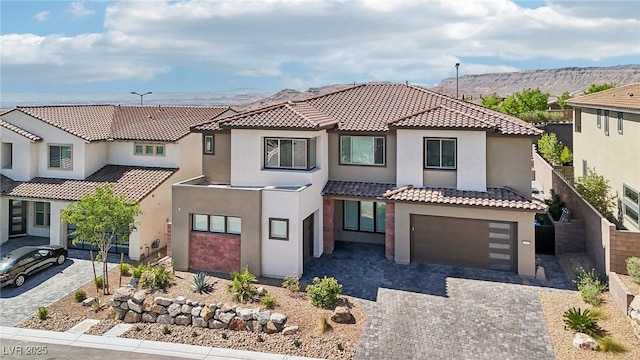 12155 Sage Thunder Ave, Las Vegas, NV 89138 - mediterranean / spanish-style home with stucco siding, decorative driveway, a garage, a tiled roof, and a mountain view
