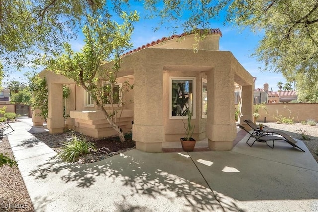 5142 Southern Hills Ln, Las Vegas, NV 89113 - rear view of house with stucco siding, a patio, fence, and a tile roof