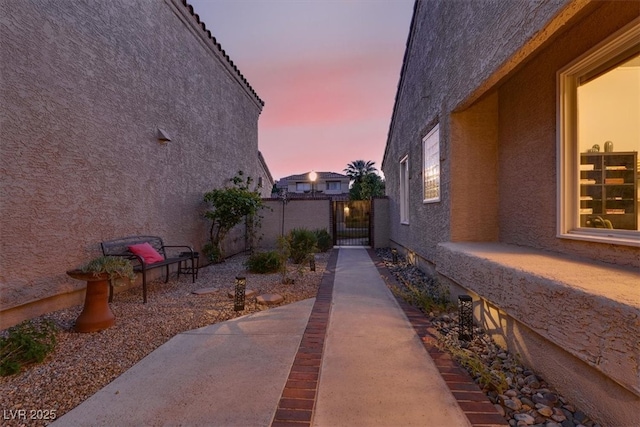 5142 Southern Hills Ln, Las Vegas, NV 89113 - view of side of home featuring stucco siding, fence, a gate, and a patio