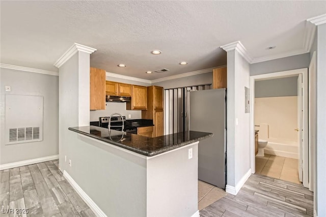 kitchen featuring stainless steel appliances, ornamental molding, under cabinet range hood, brown cabinets, and light wood-style floors