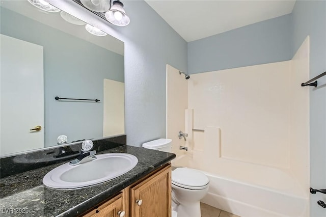 bathroom featuring toilet, shower / washtub combination, vanity, and tile patterned floors