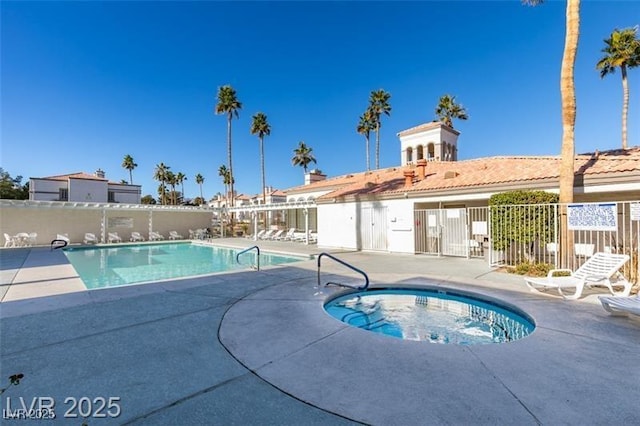 community pool featuring a community hot tub, a patio, and fence